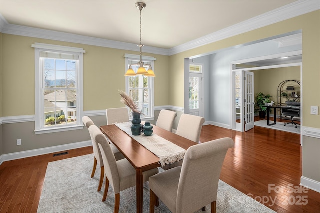 dining space featuring a wealth of natural light, visible vents, baseboards, and wood finished floors