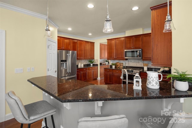 kitchen with backsplash, ornamental molding, a peninsula, a kitchen breakfast bar, and stainless steel appliances