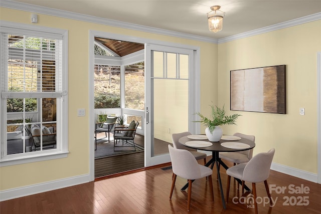 dining space featuring dark wood-style floors, baseboards, and ornamental molding