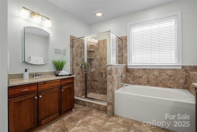 bathroom with a shower stall, vanity, and a garden tub