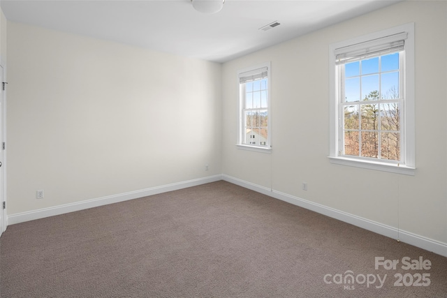 spare room with visible vents, baseboards, and carpet flooring