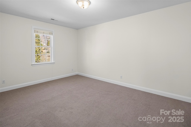 carpeted spare room featuring visible vents and baseboards