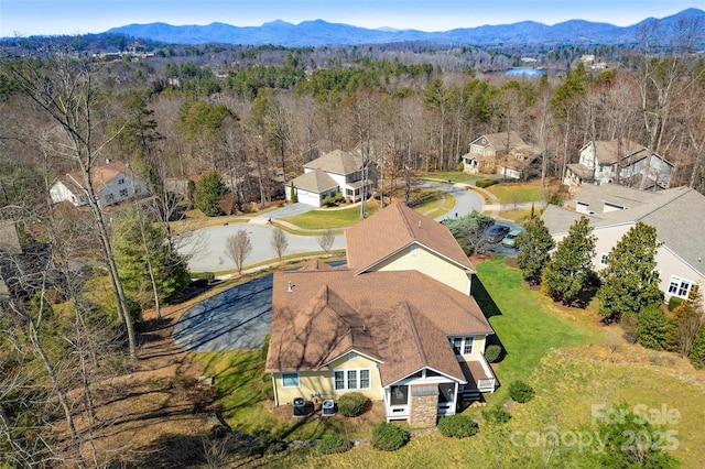 drone / aerial view featuring a mountain view and a wooded view