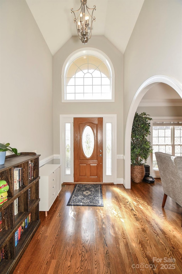 foyer featuring a chandelier, high vaulted ceiling, and wood finished floors