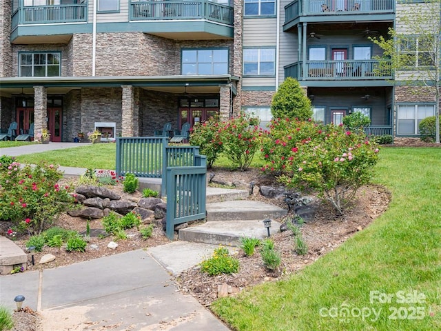 exterior space featuring stone siding and a yard