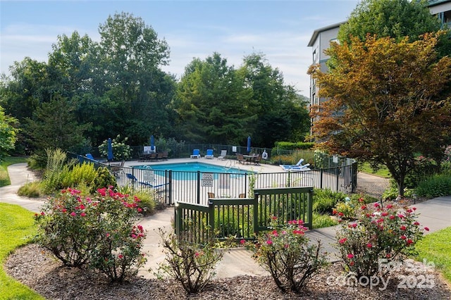 pool with a patio area and fence