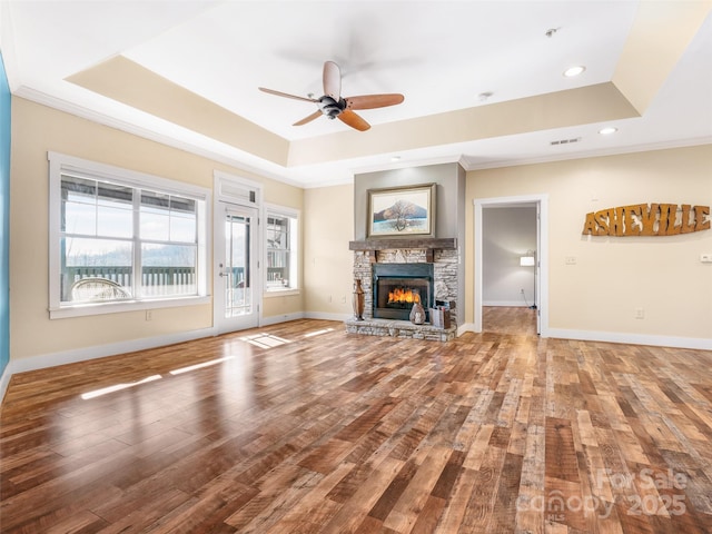 unfurnished living room with a raised ceiling, baseboards, and hardwood / wood-style floors