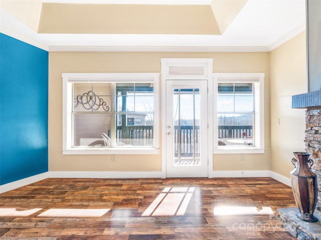 entryway with baseboards, dark wood-style flooring, a raised ceiling, and crown molding