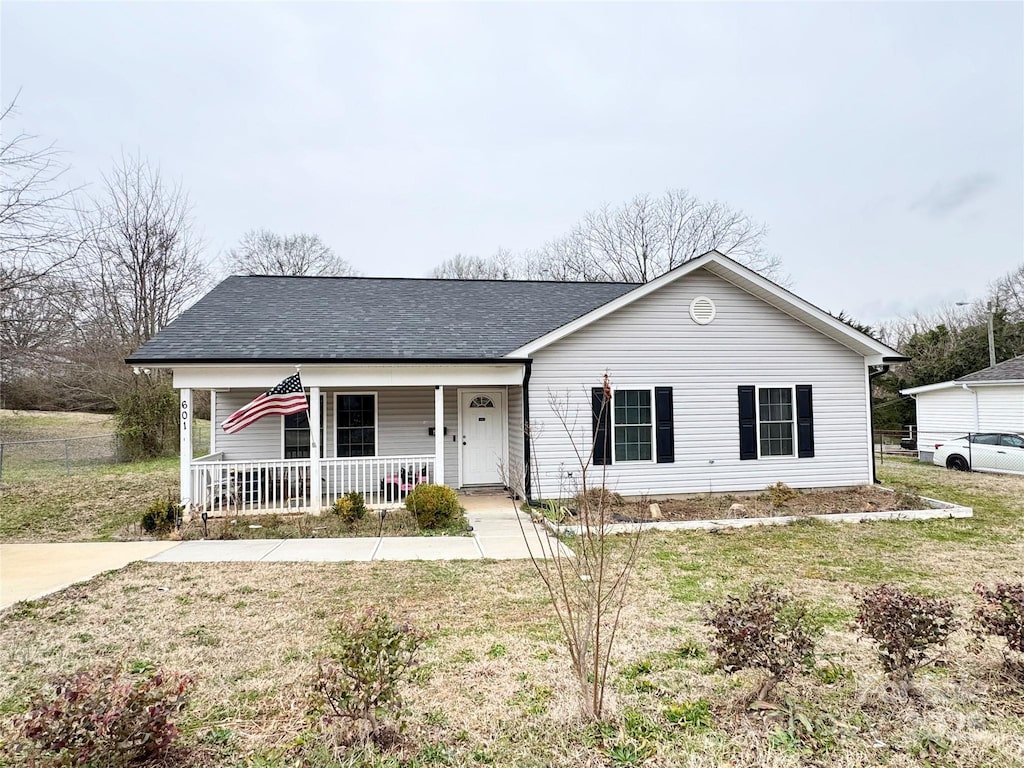 ranch-style house featuring covered porch and a front yard