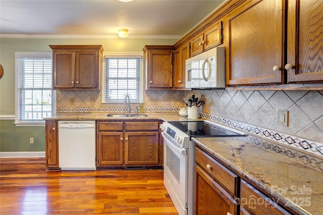 kitchen featuring white appliances, crown molding, sink, and hardwood / wood-style floors