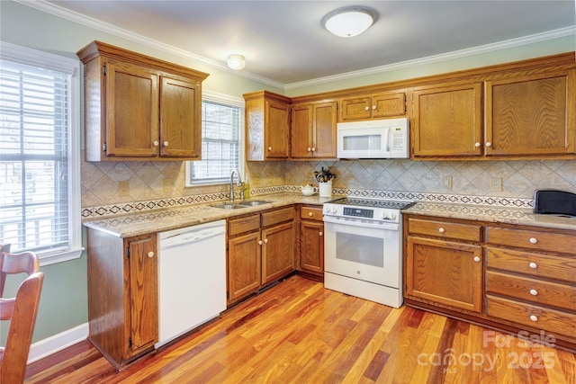 kitchen featuring sink, white appliances, crown molding, and light hardwood / wood-style flooring