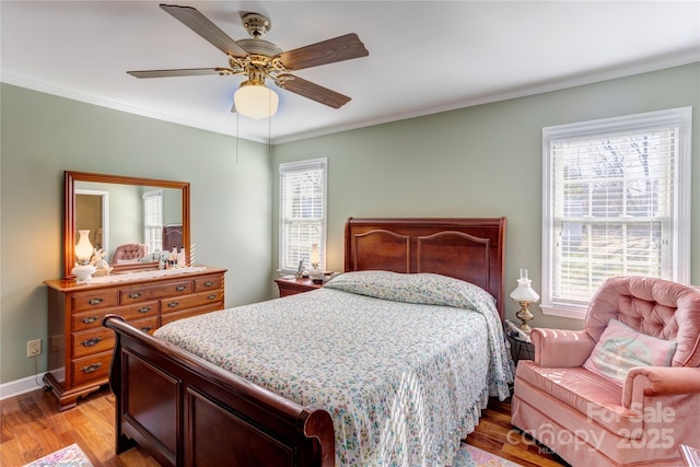 bedroom with multiple windows, crown molding, and light hardwood / wood-style floors