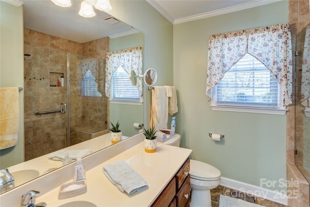 bathroom featuring vanity, crown molding, toilet, and a shower with shower door