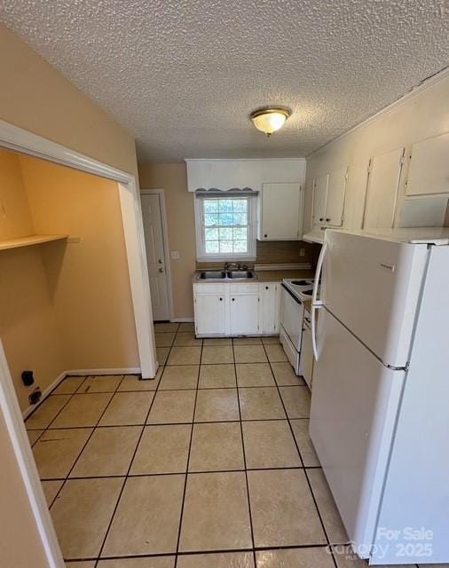 kitchen with white appliances, light tile patterned floors, sink, white cabinetry, and range hood