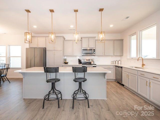 kitchen featuring stainless steel appliances, light countertops, and a center island