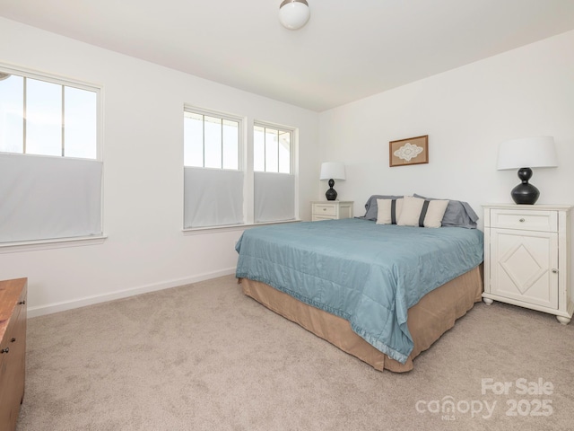 bedroom featuring baseboards and light colored carpet