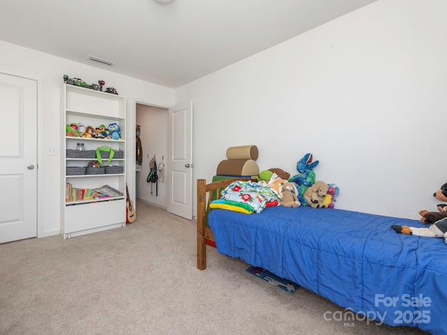 bedroom featuring visible vents and light colored carpet