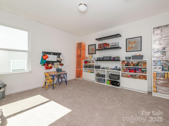 recreation room with carpet and baseboards