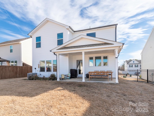 back of house with a patio, a lawn, and a fenced backyard