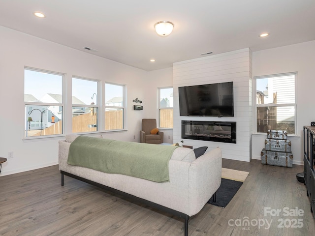 living room with dark wood-style floors, plenty of natural light, a fireplace, and recessed lighting