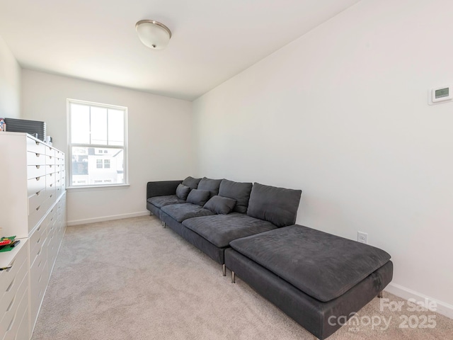 living area featuring light carpet and baseboards