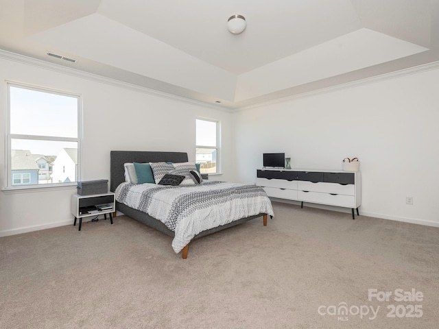 bedroom with light colored carpet, a raised ceiling, visible vents, and baseboards