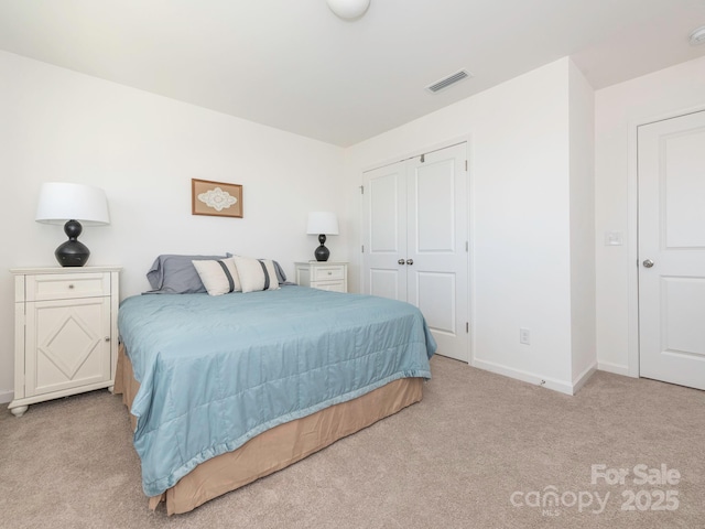 bedroom with light carpet, baseboards, visible vents, and a closet