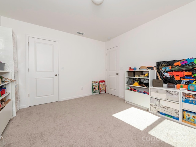 rec room with light colored carpet, visible vents, and baseboards