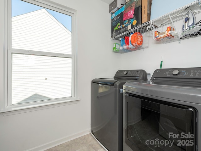 laundry area with laundry area, baseboards, washer and clothes dryer, and light tile patterned flooring