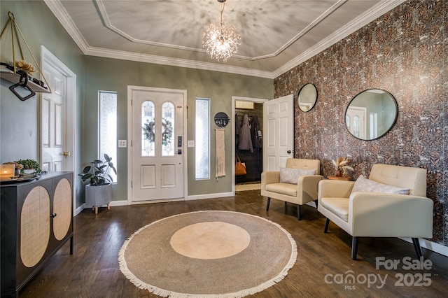 entryway featuring crown molding, dark hardwood / wood-style flooring, and a chandelier