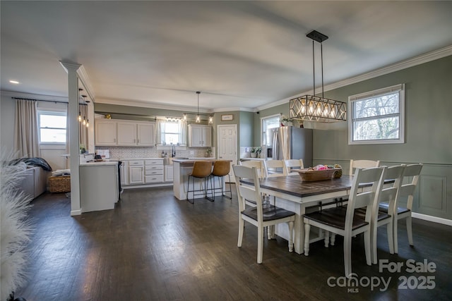 dining area featuring ornamental molding and dark hardwood / wood-style flooring