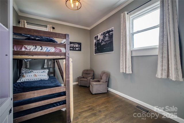 bedroom with ornamental molding and dark hardwood / wood-style floors