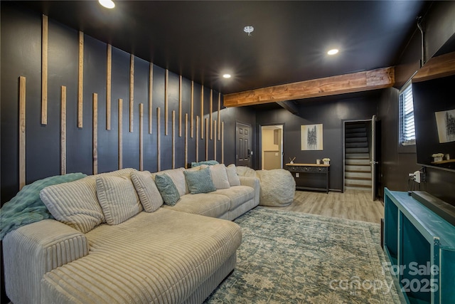 cinema room with beam ceiling and light wood-type flooring