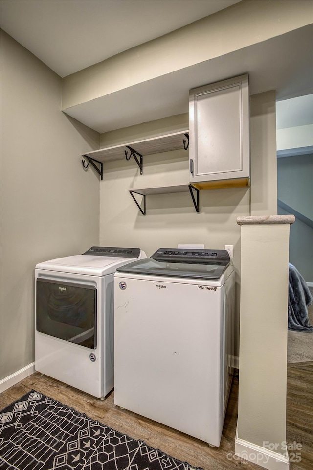 laundry area with cabinets, wood-type flooring, and independent washer and dryer