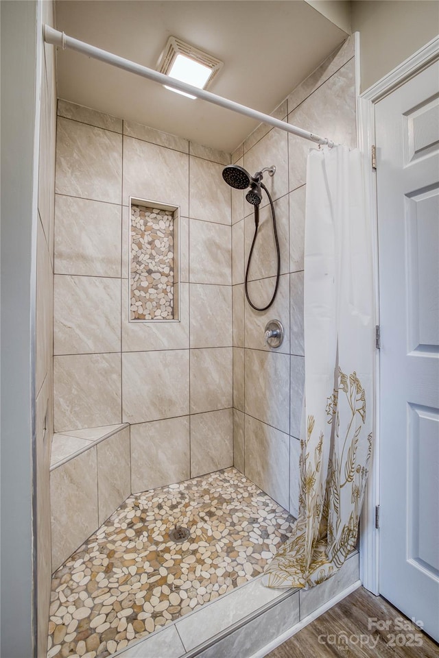 bathroom featuring hardwood / wood-style floors and a shower with shower curtain