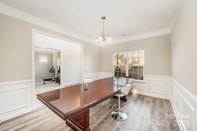 office area featuring a chandelier, visible vents, wainscoting, and wood finished floors