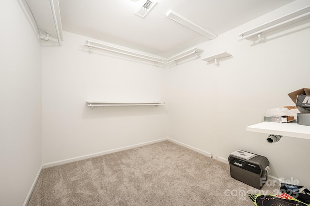 walk in closet with visible vents and light colored carpet