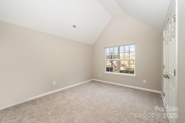 unfurnished bedroom with baseboards, visible vents, carpet, and high vaulted ceiling