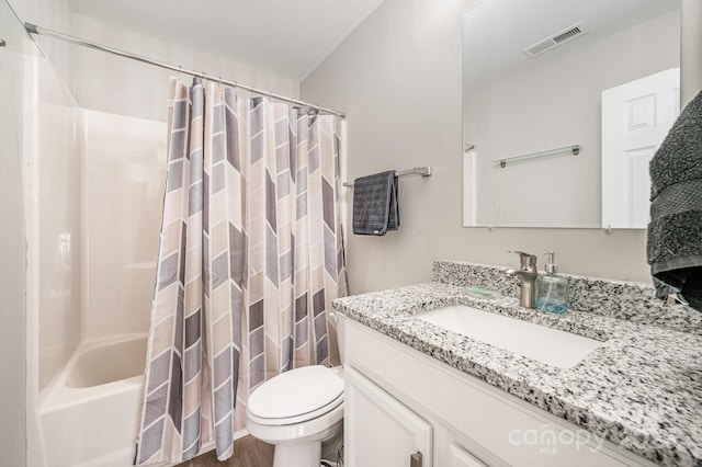 bathroom featuring shower / bath combo with shower curtain, visible vents, vanity, and toilet