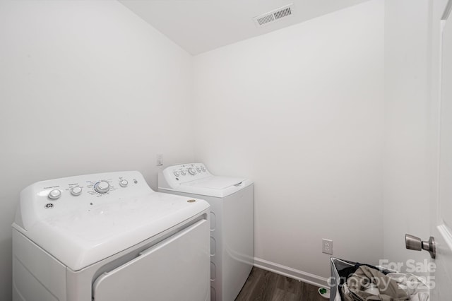 laundry area featuring visible vents, baseboards, laundry area, washer and dryer, and dark wood-style flooring