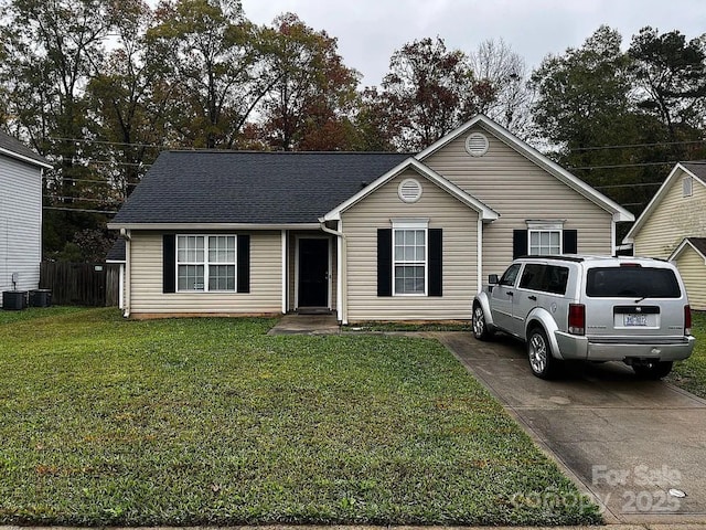 ranch-style home featuring concrete driveway, roof with shingles, and a front lawn