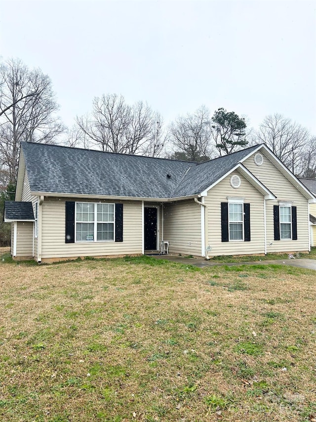 single story home featuring a shingled roof and a front yard