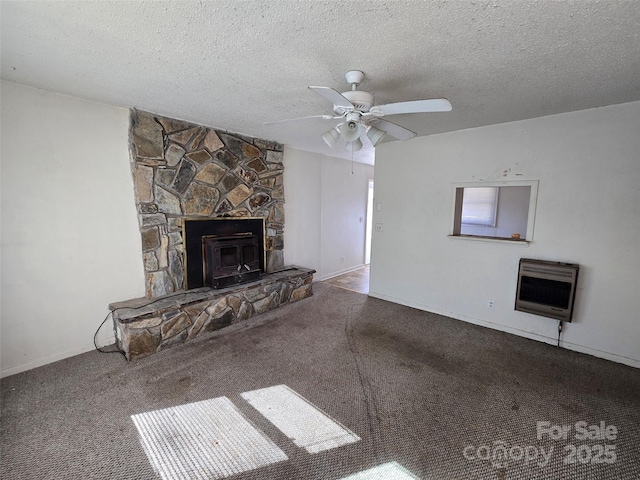 unfurnished living room featuring a stone fireplace, heating unit, carpet, ceiling fan, and a textured ceiling