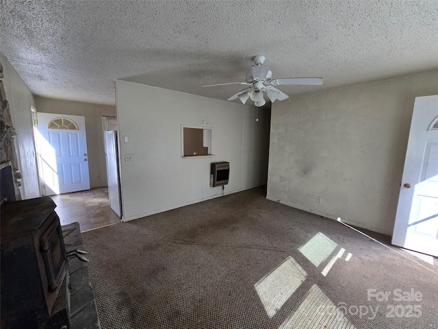 unfurnished living room with ceiling fan, a textured ceiling, heating unit, and dark colored carpet