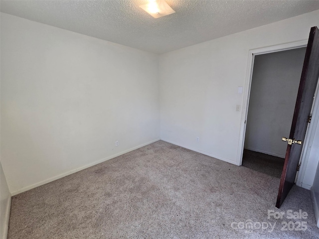 empty room featuring carpet floors and a textured ceiling