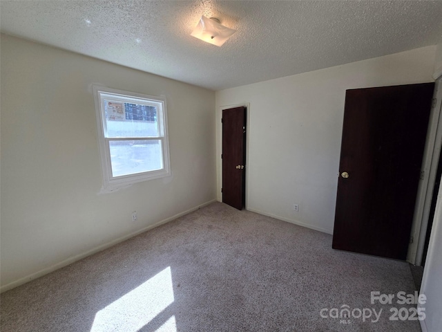 unfurnished bedroom featuring light carpet and a textured ceiling