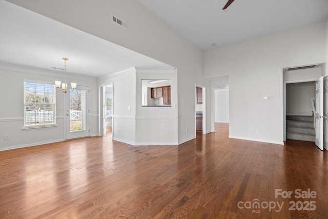 unfurnished living room featuring visible vents, dark wood finished floors, baseboards, and stairs