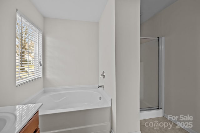 bathroom with a garden tub, a shower stall, and vanity