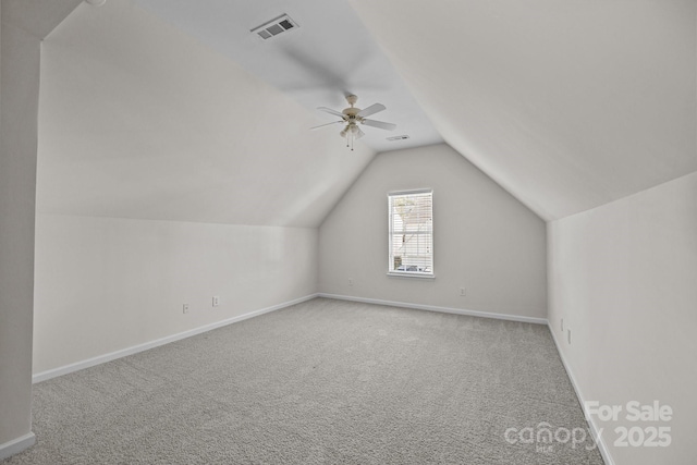 additional living space with lofted ceiling, visible vents, a ceiling fan, carpet flooring, and baseboards