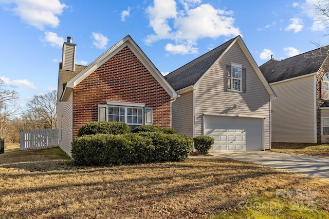 traditional-style house with brick siding, fence, concrete driveway, a chimney, and a front yard